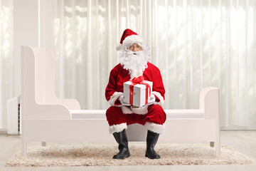 Santa claus sitting on kids bed in a room
