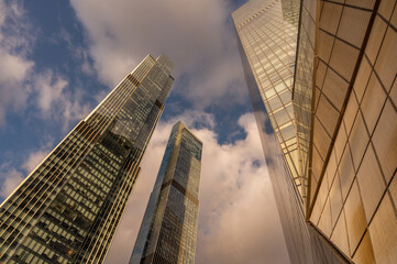 Angled view of modern skyscrapers in business district against blue sky. Looking Up high-rise...