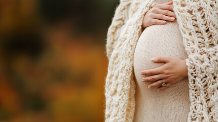 A close-up of a pregnant woman holding her belly while wrapped in a cozy knitted blanket, evoking warmth, comfort, and the nurturing essence of motherhood during the autumn season