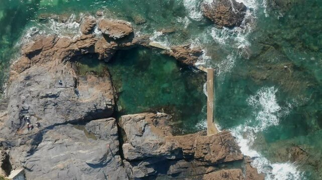Aerial view of the beautiful rocky shore and clear blue ocean with waves, Trevone, Cornwall, United Kingdom.