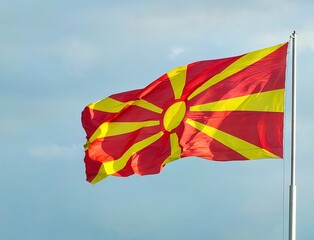 Macedonian Flag Waving in the Wind: Red and Yellow National Colors Against a Clear Blue Sky