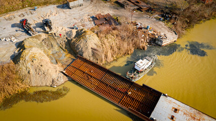 Aerial view on excavator, tow truck and tugboat as they move part of vessel