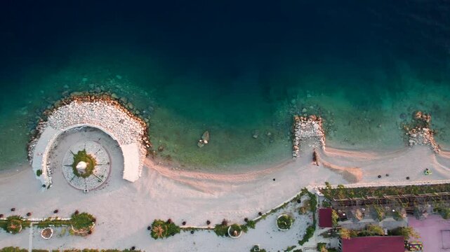 Aerial view of the beautiful sandy beach and turquoise sea with a picturesque harbour, Baska Voda, Croatia.