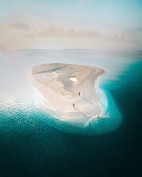 Aerial view of serene sandbar and tranquil beach at sunrise with clear turquoise water, Alif Alif Atoll, Maldives.