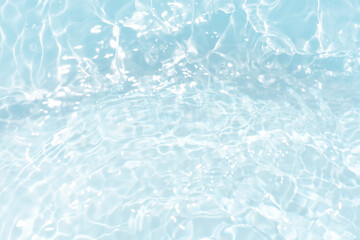 Blue water with ripples on the surface. Defocus blurred transparent blue colored clear calm water surface texture with splashes and bubbles. Water waves with shining pattern texture background.