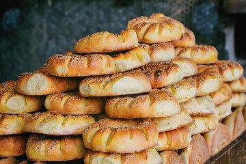 Pile of traditional Uzbek bread with sesame seeds, golden brown and freshly baked, showcasing the texture and details of each loaf. Tashkent, Uzbekistan