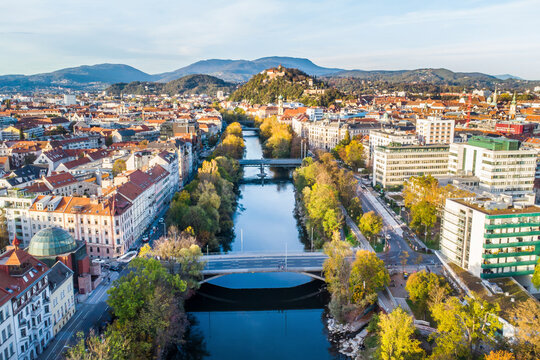 Aerial view of autumn cityscape with river Mur, Schlossberg, and clocktower, Graz, Austria.