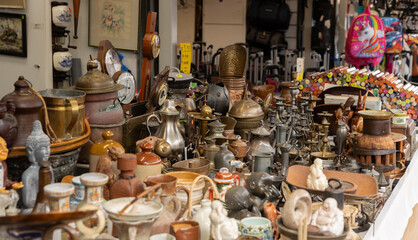 Antiques, old things, religious symbols, figurines, old ceramics and accessories for the home, offered at a market stall. Haagse Market in The Hague, Netherlands.
