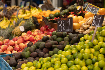Close-up of avocados surrounded by other types of fruit such as apples and lemons. Haagse Market in The Hague, Netherlands.