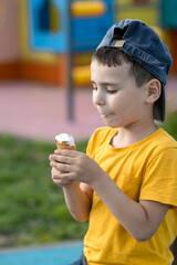 Little boy child eating ice cream in summer on playground