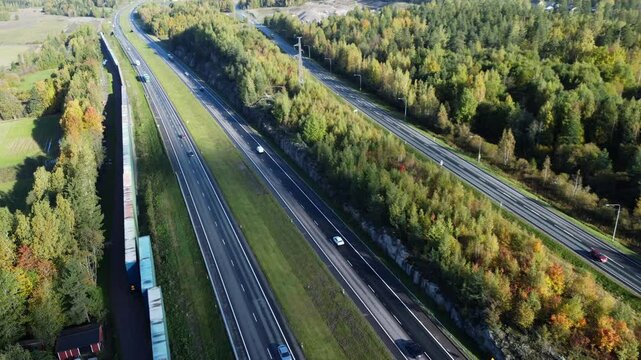 Aerial view of highway vehicle traffic through northern autumn forest