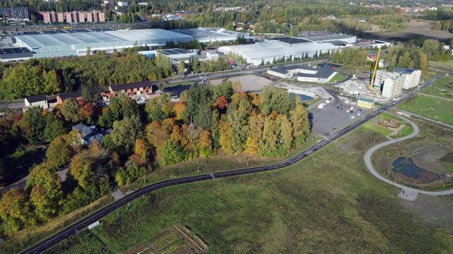 Flyover suburban warehouses with trees in bright autumn colors