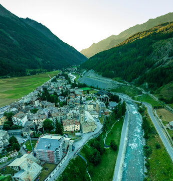 Aerial view of picturesque village nestled in the alps with a serene river and charming buildings, Cogne, Italy.