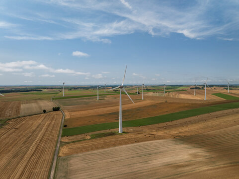 Aerial view of wind turbines in green farmland under a blue sky, Son, Ardennes, France.