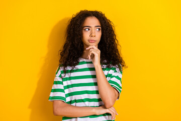 Photo of nice young girl look empty space wear striped t-shirt isolated on yellow color background