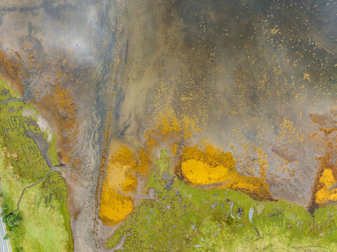 Aerial view of loch leven at low tide with serene wetlands and lush vegetation, ballachulish, scotland.