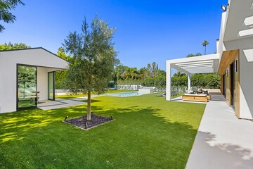 Modern luxury home with pool and patio.