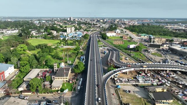 Aerial view of bustling mile one flyover with moving cars and modern buildings, Port Harcourt, Nigeria.