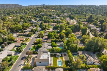 Obraz premium Aerial view of a suburban neighborhood with a modern house and pool.