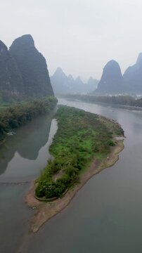 Aerial view of beautiful karst mountains and a meandering river in a serene valley, Guilin, China.