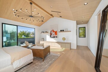 Modern bedroom with wooden ceiling and minimalist decor.