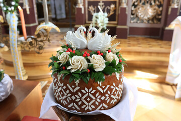 Traditional wedding loaf with swans on a stand in the church.