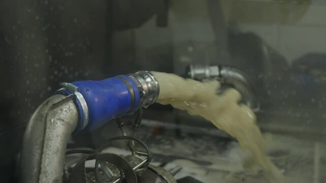 Cargo truck vehicle dpf (Diesel Particulate Filter) filter cleaning process with dirty liquid of different colors flows out of the filter under pressure