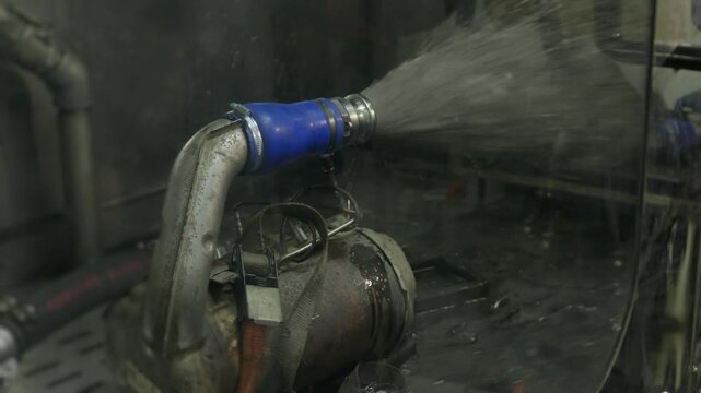 Process of cargo truck vehicle dpf (Diesel Particulate Filter) filter cleaning with dirty black liquid flows out of the filter under pressure
