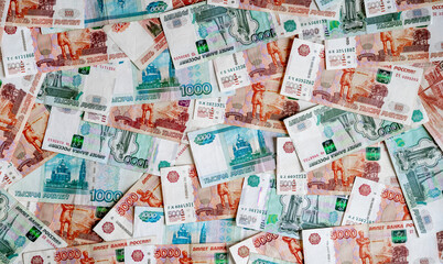 Russian money rubles in denominations of five thousand Russian rubles and one thousand Russian rubles are scattered all over the photograph, the background is made of money