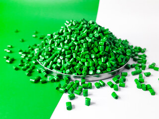 Green masterbatch granules on a white and green background. Color pigment carrier polymer in the...