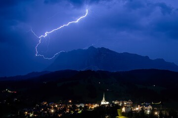 Lightning bolt above the Dolomites mountains on Monte Croce cross mountain san leonardo val badia...