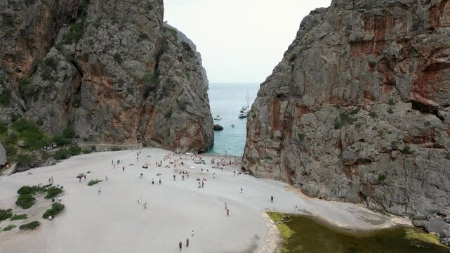 Lots of tourists walking around the beach, massive cliffs, Sa Calobra, Mallorca