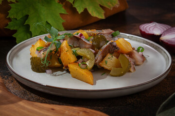 Russian cuisine. Potatoes with herring and pickled cucumbers