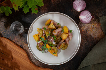 Russian cuisine. Potatoes with herring and pickled cucumbers
