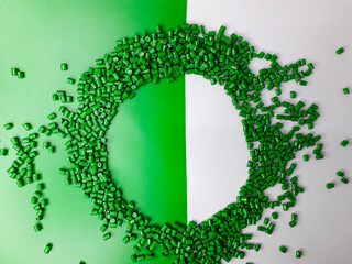 Green masterbatch granules on a white and green background. Color pigment carrier polymer in the...