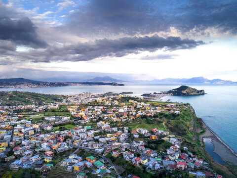 Aerial view of beautiful Procida Island with picturesque homes and tranquil sea, Monte di Procida, Italy.