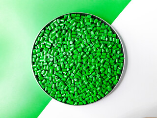 Green masterbatch granules on a white and green background. Color pigment carrier polymer in the...