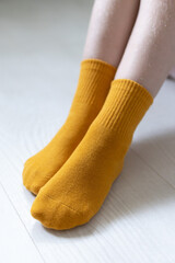 Baby feet in yellow socks on a white background
