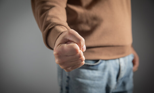 Caucasian angry and aggressive man threatening with fist.