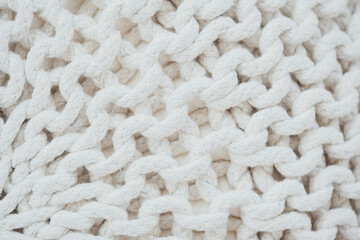 Close-up of textured white knitted fabric showcasing intricate weaving patterns