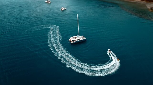 Aerial view of luxury yachts and speedboats navigating the beautiful blue ocean, Whitsundays, Australia.