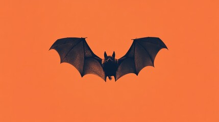 Naklejka premium A small black bat flying in the center of a plain orange background 
