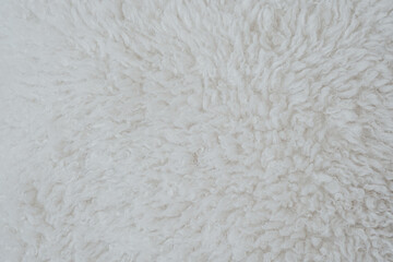 Soft, fluffy white rug texture in natural light highlighting its cozy and inviting appearance