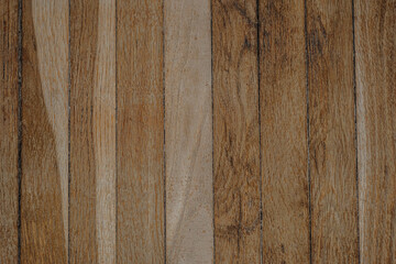 Wooden planks arranged neatly showing natural grain patterns in warm tones during daylight