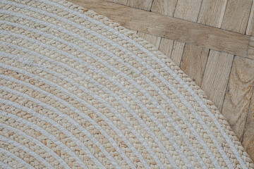 A close-up view of a woven rug on a wooden floor highlighting its texture and design