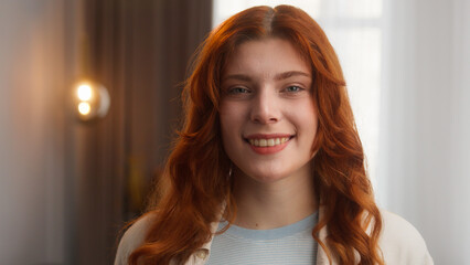 Pleased positive Caucasian woman portrait model redhead girl posing glad 20s young female smiling with dental healthy teeth happy lady headshot looking at camera at home apartment joy emotion wellness