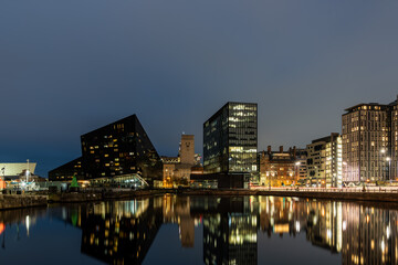 The modern buildings of liverpool are reflecting in the water of the docks