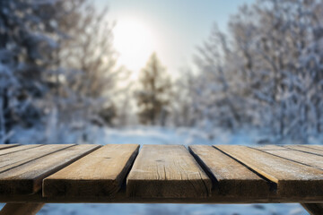 Fototapeta premium Empty wooden table top with blurred winter forest background for product display and presentation