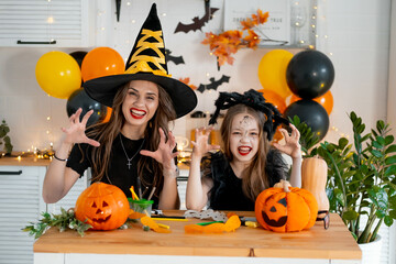 A happy family is getting ready for Halloween. Mother and child daughter in carnival costumes at...