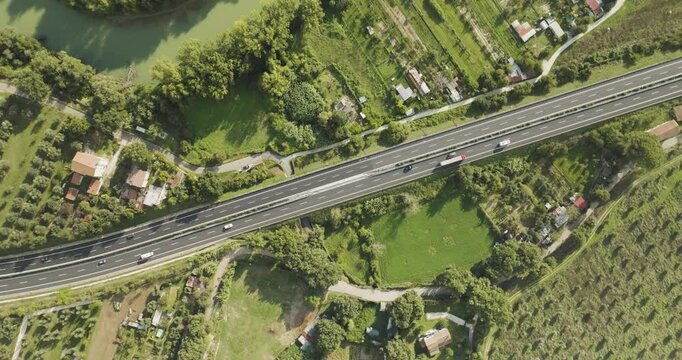 Aerial view of a beautiful highway surrounded by lush greenery and fields with scattered houses, Orte, Italy.